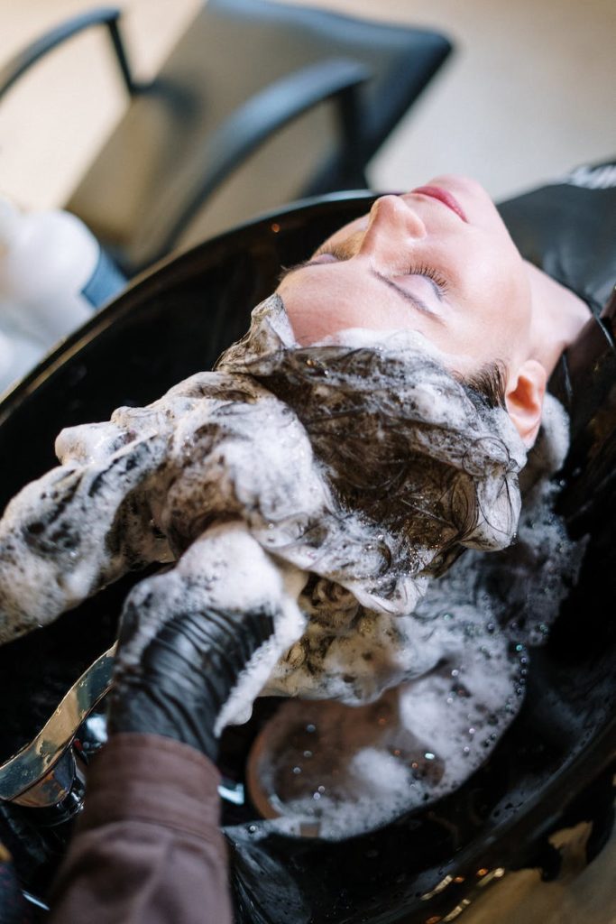 woman getting her hair shampoo